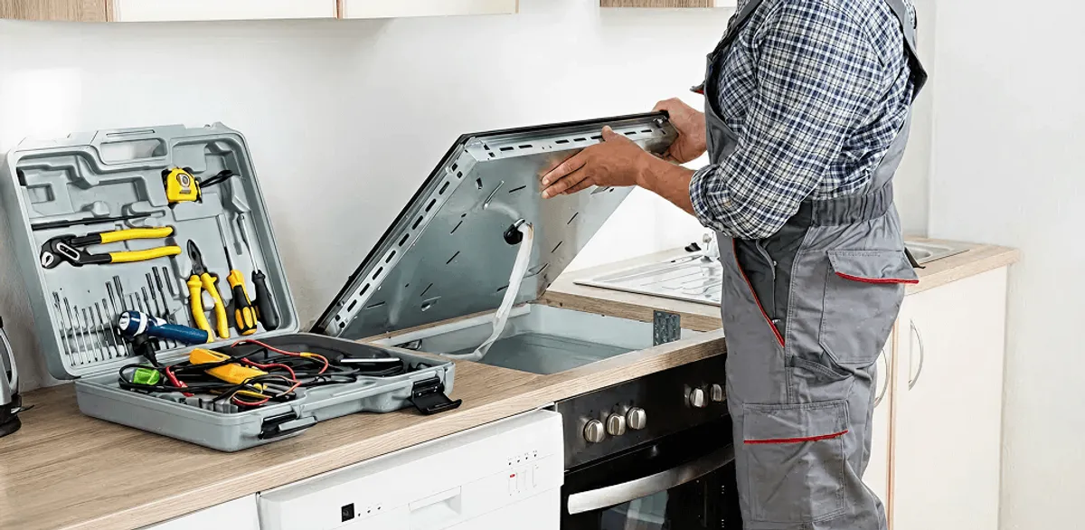 Handyman repairing a cooktop and checking wiring connections in Sioux Falls, SD